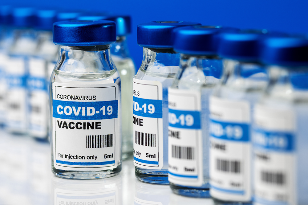 multiple Covid-19 Coronavirus vaccination vials with blue lids and white labels